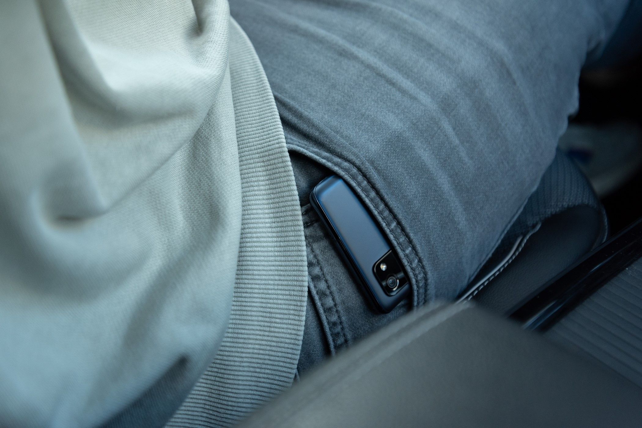 A man driving with his phone kept in his jeans pocket