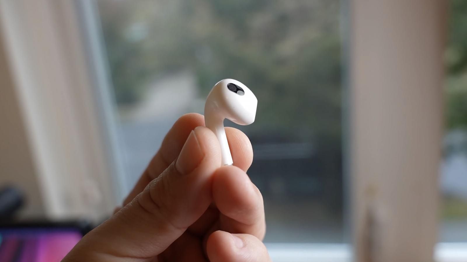 Earbud held in hand by the stem